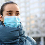 Girl wearing disposable mask outdoors during covid