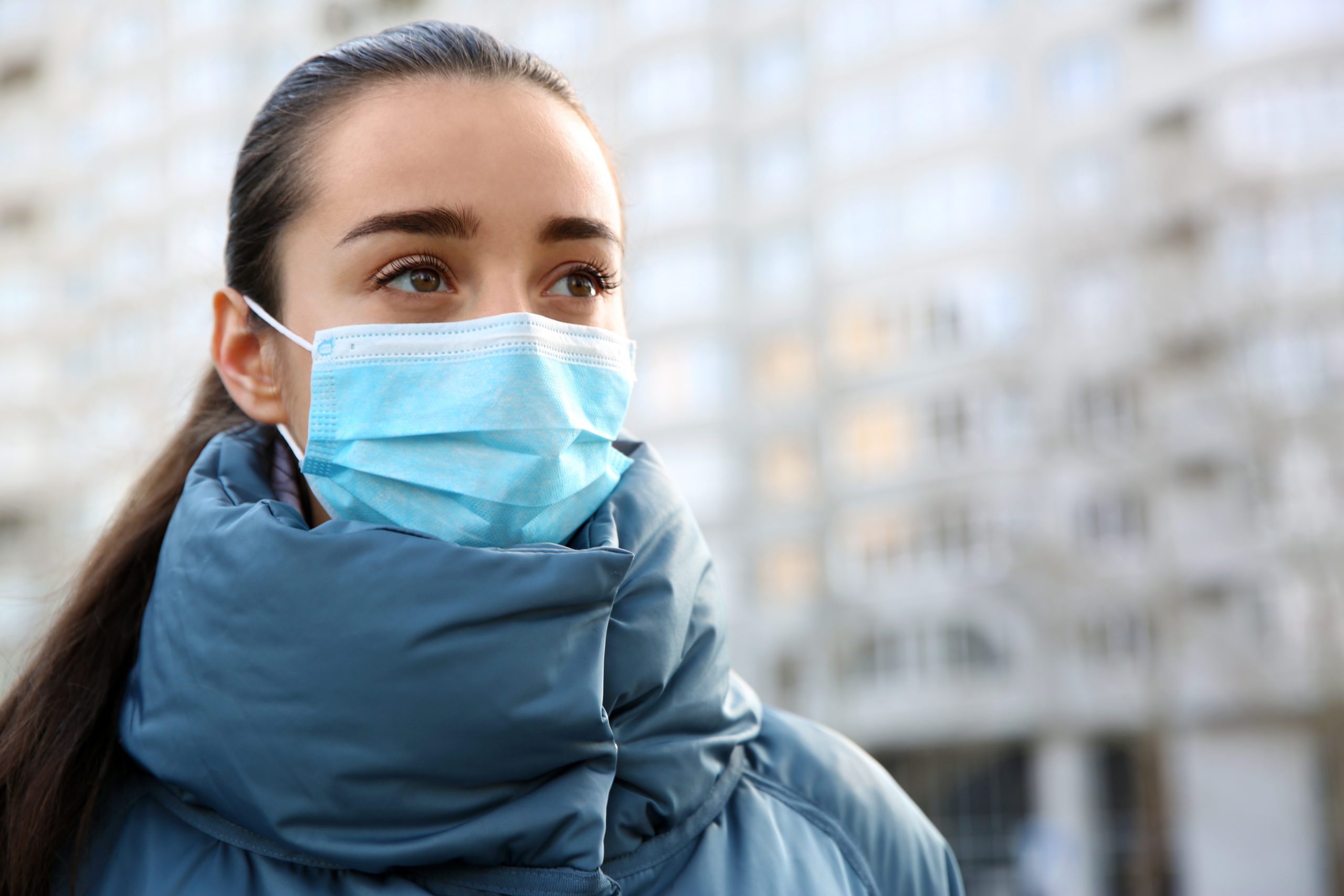 Girl wearing disposable mask outdoors during covid
